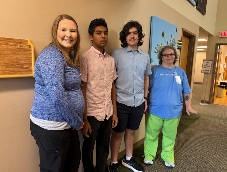 Cedar Falls High School students Ahan Tandon and Mihai Thompson volunteering with Waverly Health Center staff to help patients access the online portal.
